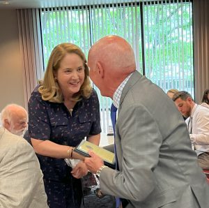 Elizabeth Wright giving 50-year recognition plaque to recipient who became licensed with the Utah State Bar in 1974.
