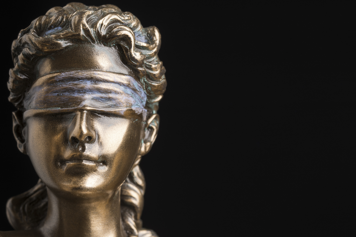 Portrait of the blindfolded goddess of justice Themis isolated on black background with copy space, as a legal concept